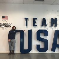 Anthony S. Ferraro standing in front of Team USA sign at Olympic Training Center, Colorado Springs