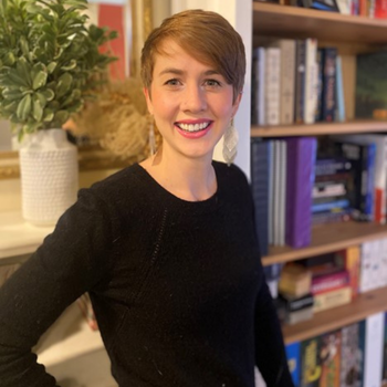 headshot of Katrina Stratton smiling in front of bookcase