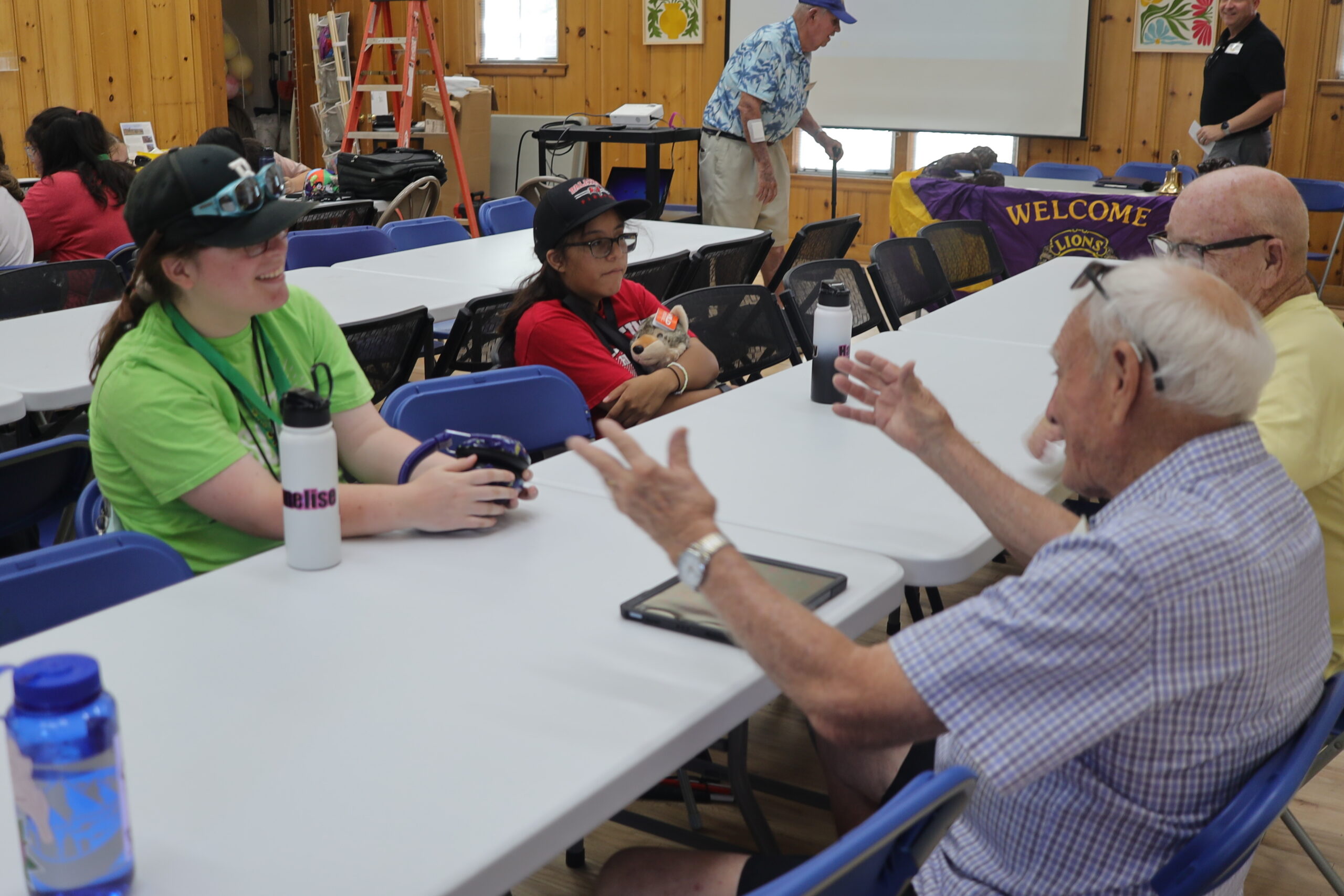 campers and Lions sit at a long table, talking.